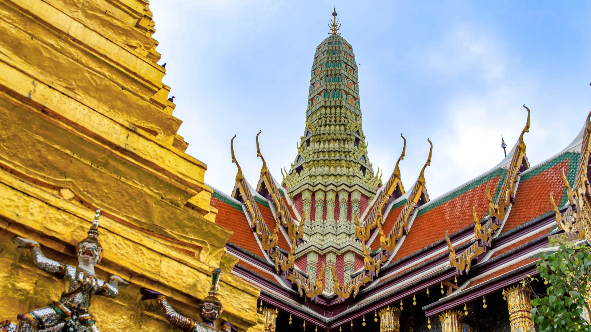 Vue rapprochée du chedi doré et du prang finement décoré du Wat Phra Kaew (Temple du Bouddha d'Émeraude) au Grand Palais, Bangkok, Thaïlande.
