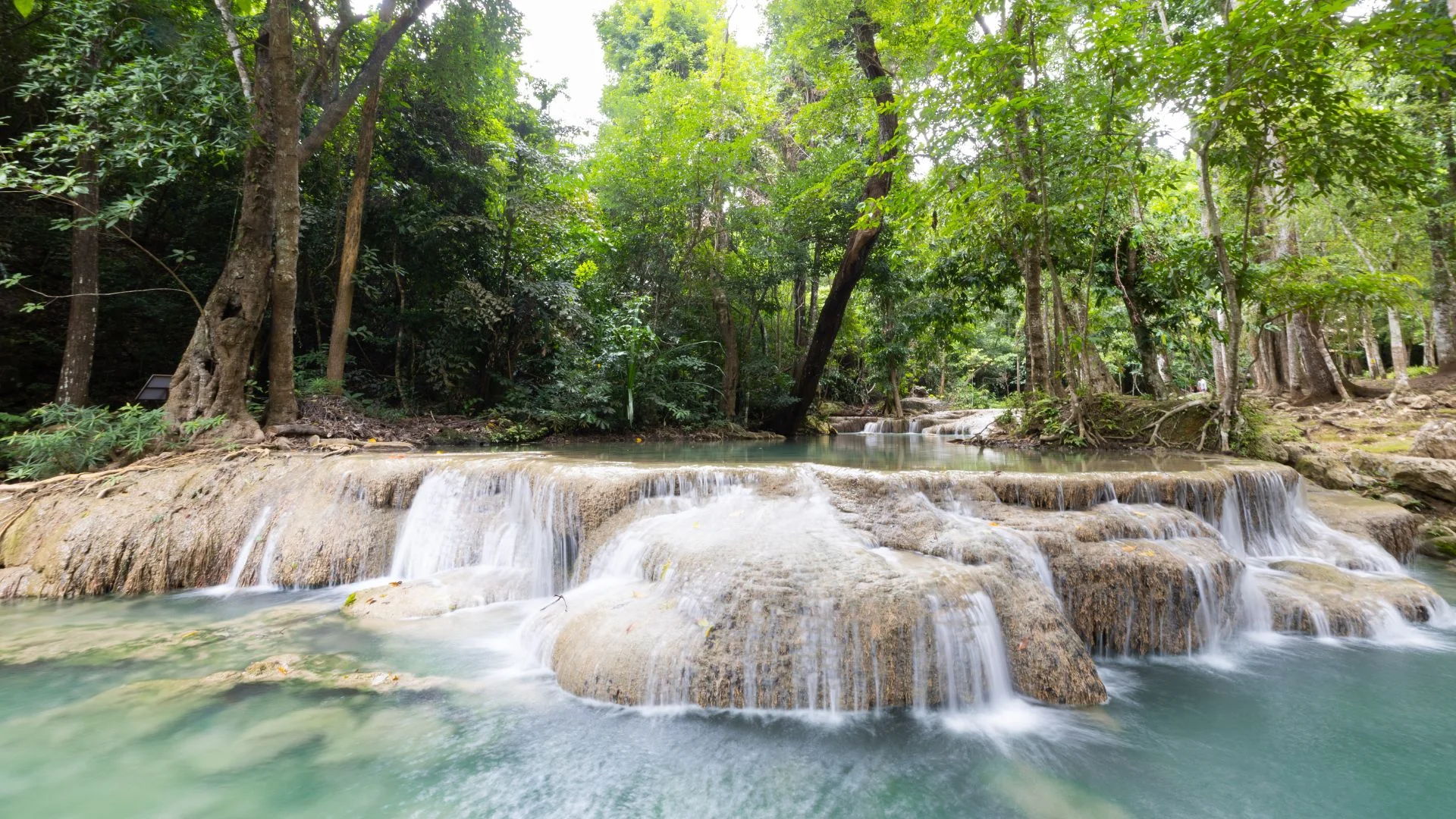 Vue imprenable sur les cascades d'Erawan et leurs piscines naturelles aux eaux émeraude dans la jungle de Kanchanaburi.