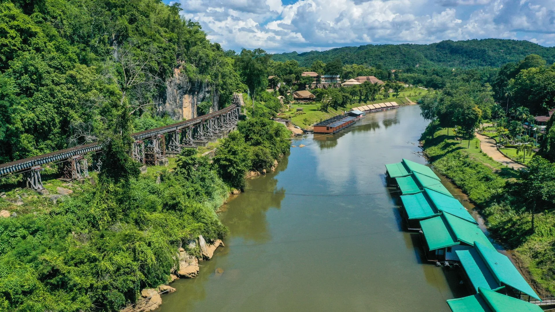 Voyageurs se baignLa célèbre voie ferrée de la mort (Death Railway) serpentant le long de la rivière Kwai à Kanchanaburi, Thaïlande.ant dans les cascades d'Erawan aux eaux émeraude lors d'une excursion Safarine Tours à Kanchanaburi.